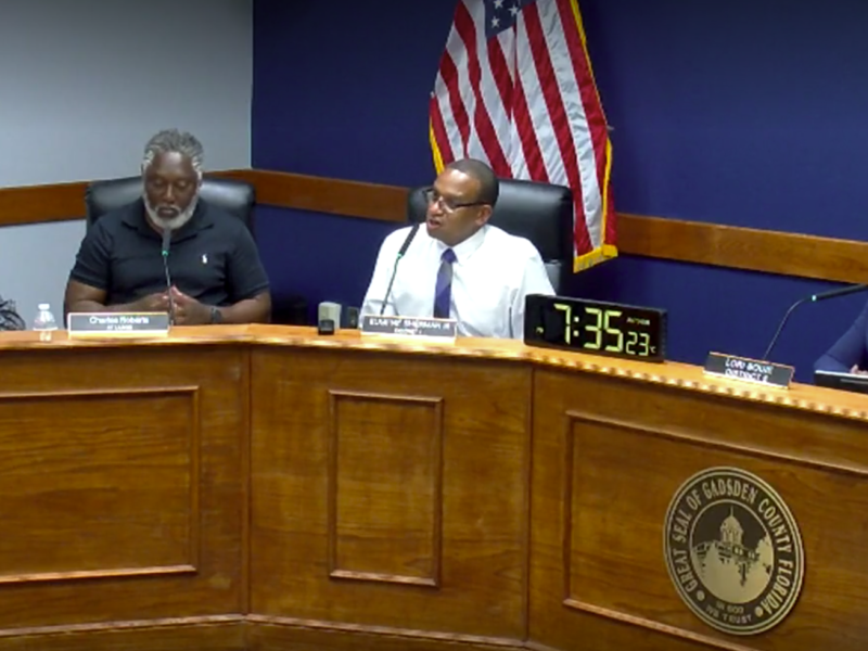 Gadsden County Board of County Commissioners meeting in session, with officials seated at the dais discussing agenda items in a formal chamber setting.