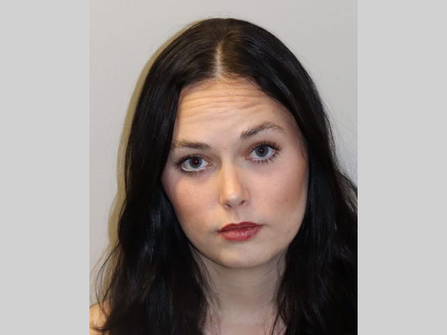 Portrait of a woman with dark hair facing the camera against a plain background.