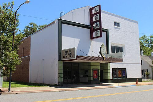 Exterior view of the historic Leaf Theatre in Quincy, Florida, showing the white theater building with a vertical marquee sign along a downtown street