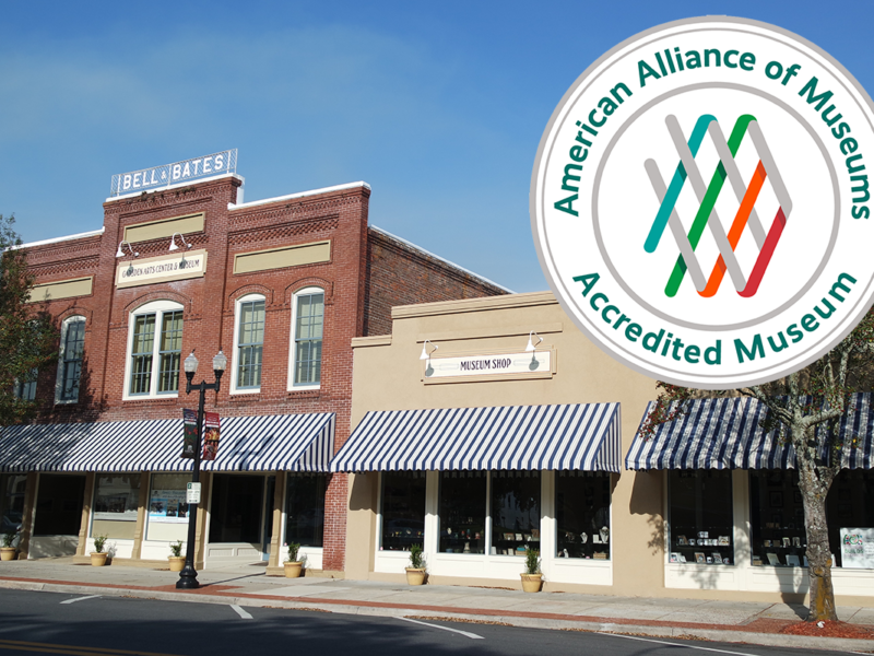 Exterior street view of the historic Gadsden Arts Center & Museum in Quincy featuring brick architecture, striped awnings, and an inset seal showing American Alliance of Museums accreditation.