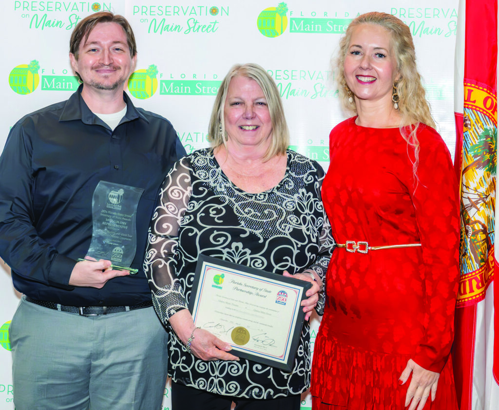 Quincy Main Street Director Josh Kever and Melissa Wylie, CEO of the Florida Trust for Historic Preservation, presenting the 14th Colony Representative Award to Dawn McMillan.