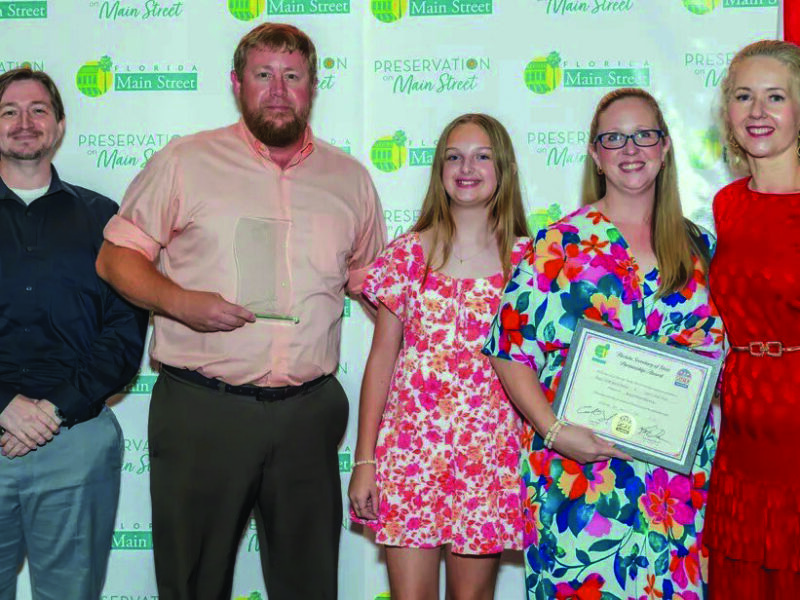 Group photo at the Florida Main Street conference showing Josh Kever, Roger and Bridgette Rankin, their daughter Lilly, and Melissa Wylie holding an award certificate.